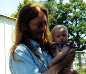Corey several years back in John Lennon mode, holding my great-niece Abrie.