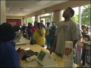 Joseph Fury considers his options inside Church's Chicken after a wait of about two hours. Waiting to take his order is employee Alyssa Webb. Image from Toledo Blade.