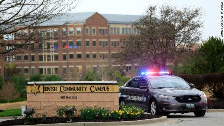 A police car sits at the entrance of the Jewish Community Campus, the scene of two of three shooting deaths Sunday in Overland Park, Kan. Image from CNN.