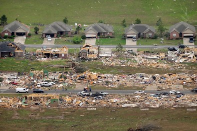 A row of lightly damages houses, top, face destroyed homes in a Vilonia neighborhood after a tornado struck the town late Sunday. Image by Danny Johnston/AP.
