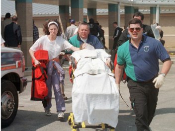 Emergency workers move one of the wounded in the Westside shooting to an ambulance. Shannon Wright, Paige Herring, Stephanie Johnson, Brittheny Varner and Natalie Brooks died in the attack. Image by Curt Hodges, Jonesboro Sun.