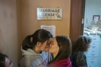 Kristin Seaton, left, and Jennifer Rambo, kiss while waiting for their marriage license Saturday at the Carroll County Courthouse in Eureka Springs. The Fort Smith couple were first in line and were later married outside the courthouse. Photo by Alexander Reyes, NWA Media.
