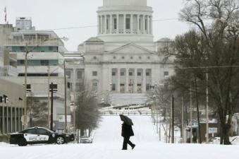 A woman walks across Capitol Avenue in Little Rock on Monday. Image by Associated Press.